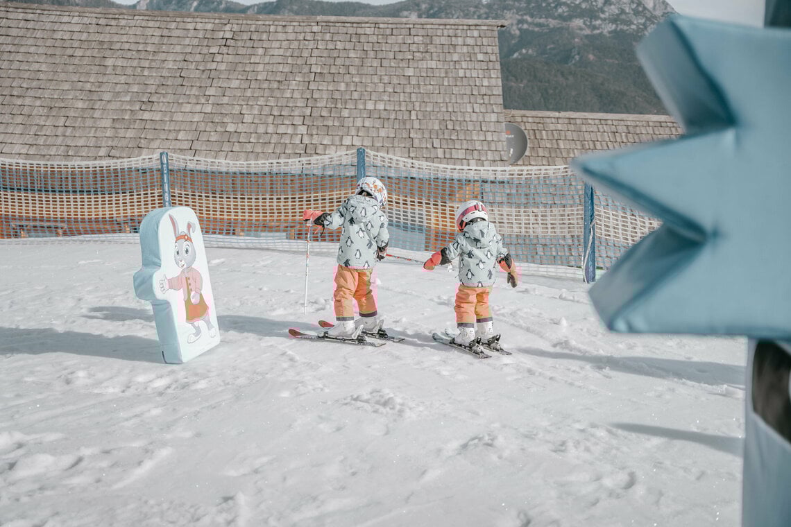 2 Kinder helfen sich beim Skifahren lernen